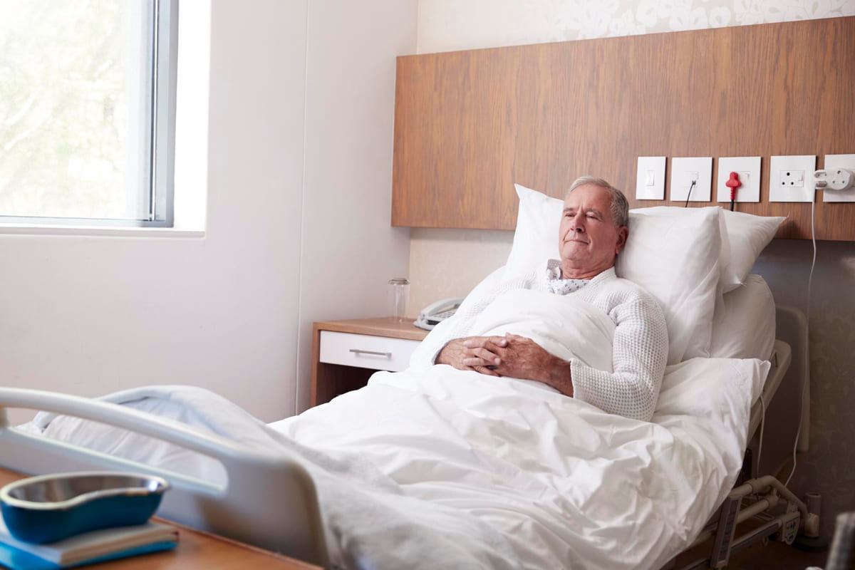 Un anciano en una cama ortopédica.