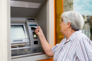 Mujer mayor insertando una tarjeta en un cajero automático