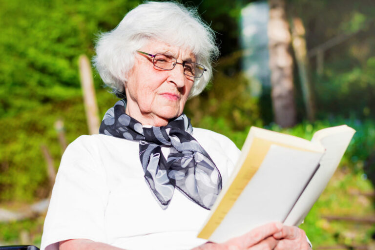 Una anciana leyendo un libro.