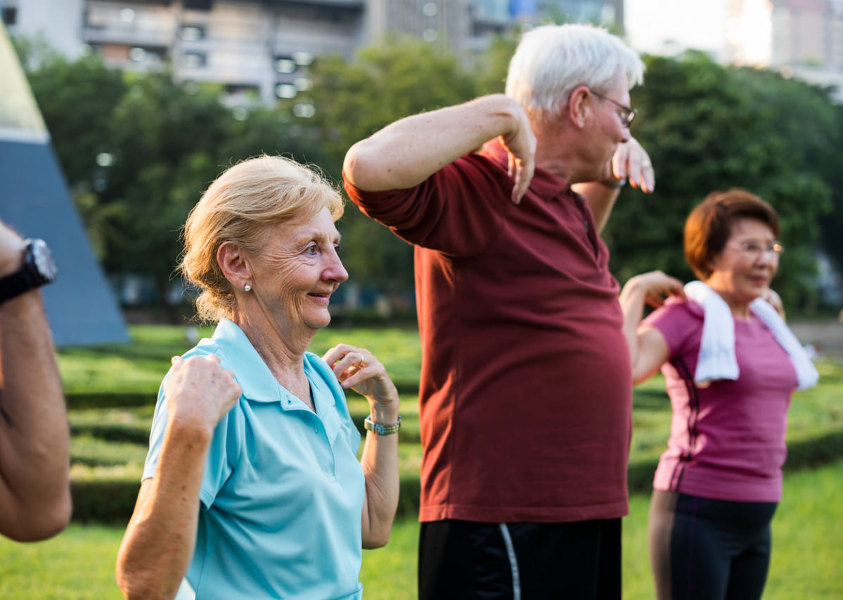 Un grupo de ancianos haciendo ejercicio al aire libre.