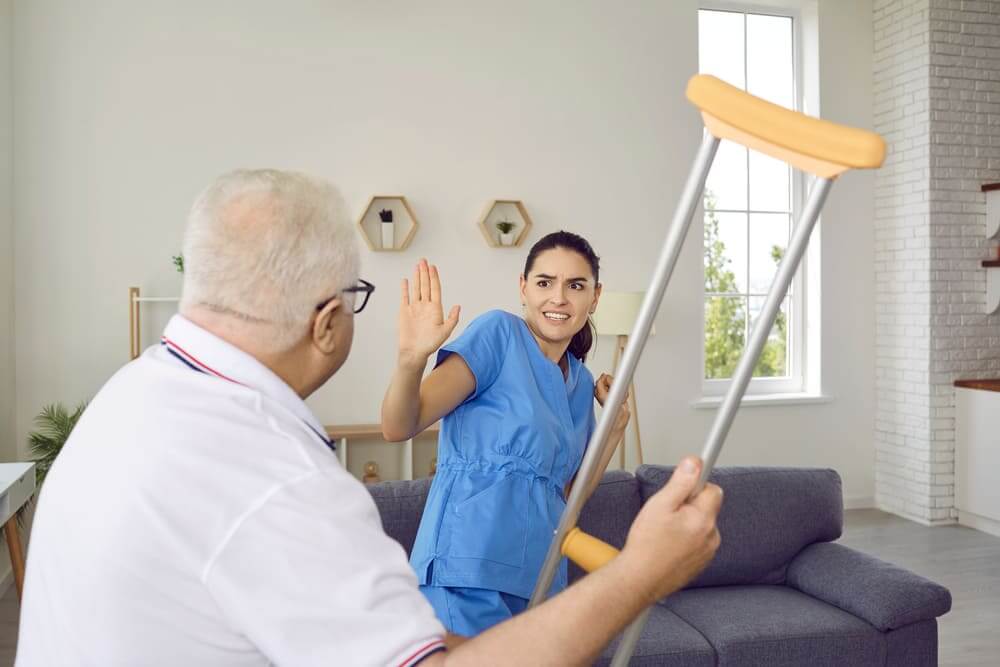 Un anciano le levanta su multa a su cuidadora en claro signo de enfado hacia ella. 