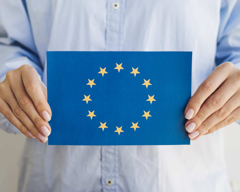 Un hombre sujeta un cartel con la bandera europea. 