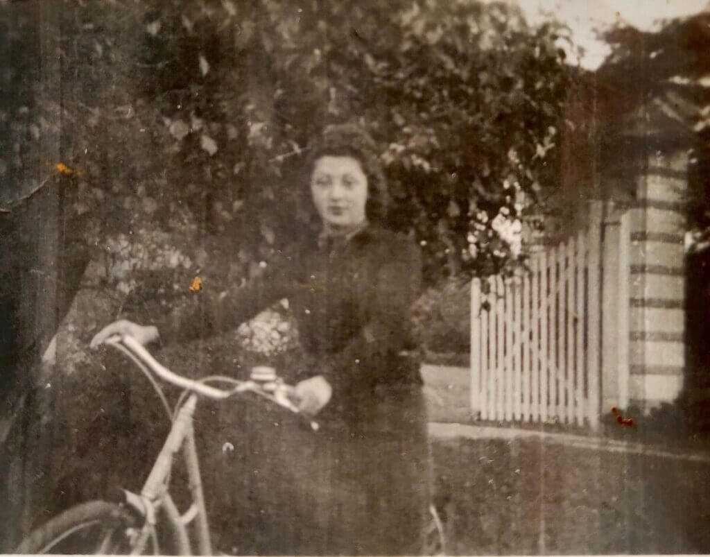 Fotografía antigua de una chica joven montando en bicicleta