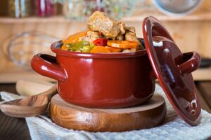 Una olla de puchero con los ingredientes lista para servir en una mesa.