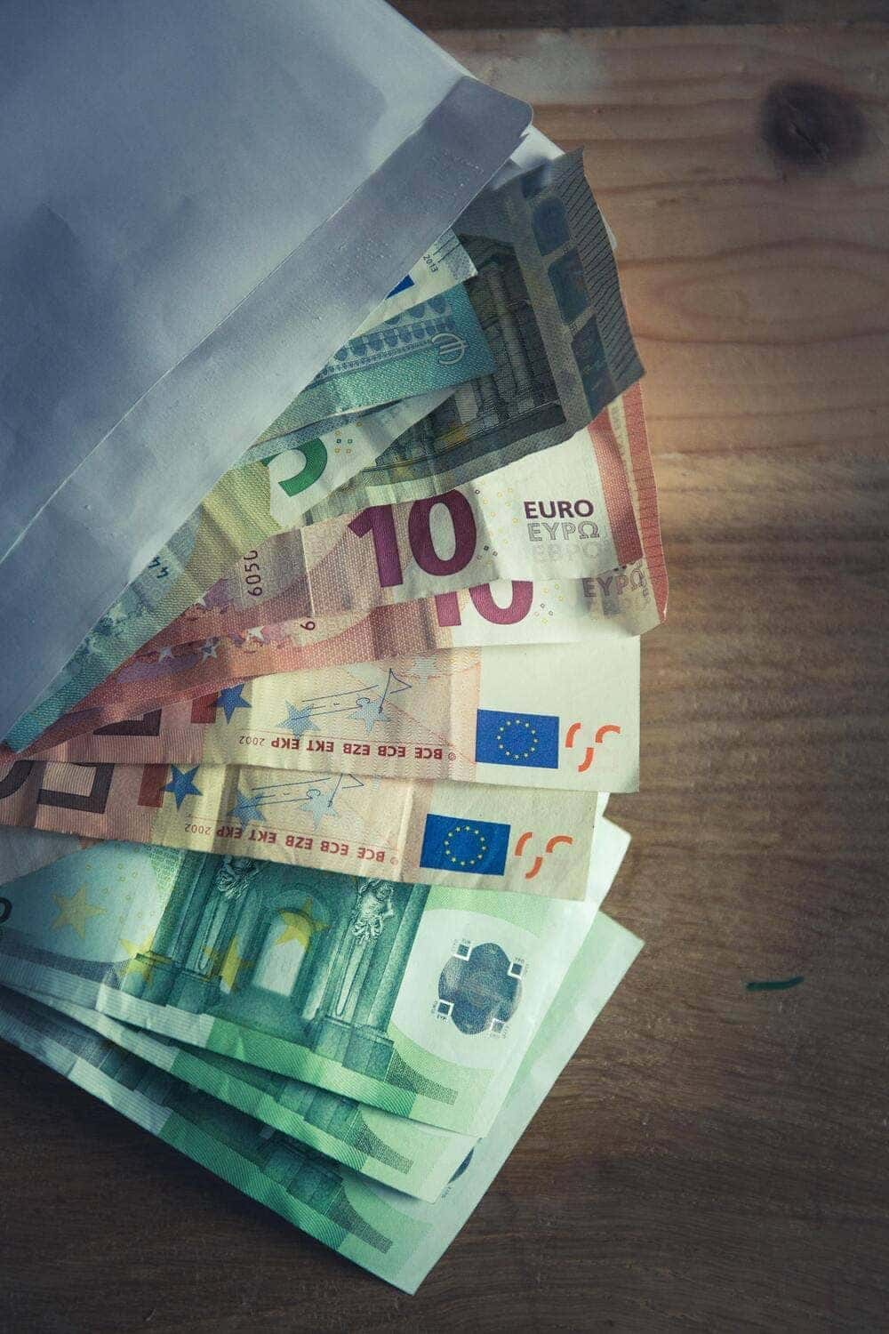 Unos billetes de euros sobre un sobre blanco. 