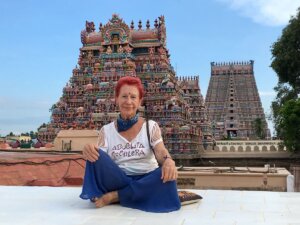 Fotografía de Kandy sentada frente a unas pirámides hindúes, con el pelo rojo