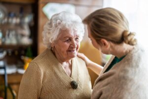 Soledad no deseada: una mujer mayor se alegra al recibir la visita de otra mujer más joven
