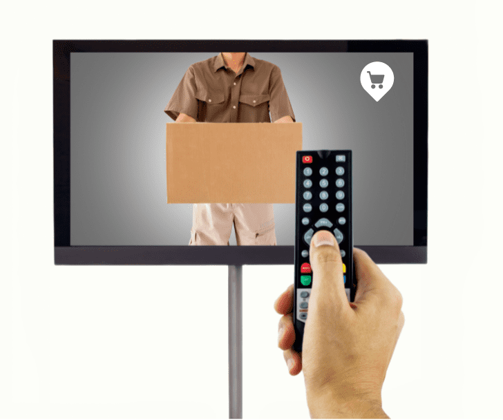 Una imagen de una mano de un señor con el mando a distancia y un programa de teletienda en la pantalla. 