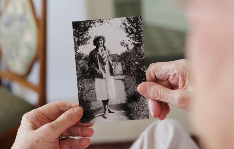 Una imagen de una persona mayor sujetando una fotografía en blanco y negro de un familiar.