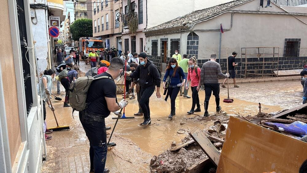 Un grupo de vecinos de Aldaia achican agua en las calles con palas tras la catástrofe natural de la DANA. 