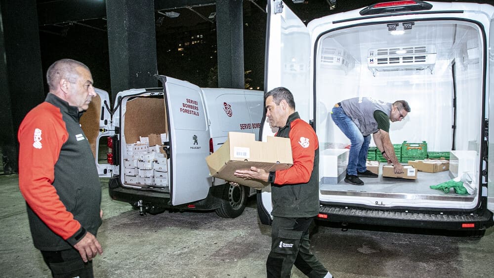 Unos hombres descargando un camión con comida para darlo a los necesitados de la DANA en Valencia. 