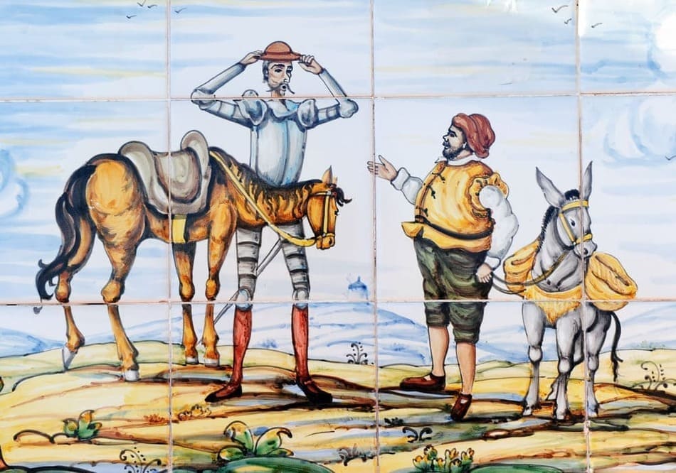 Un dibujo de Don Quijote, con su caballo, junto a Sancho y su caballo. 