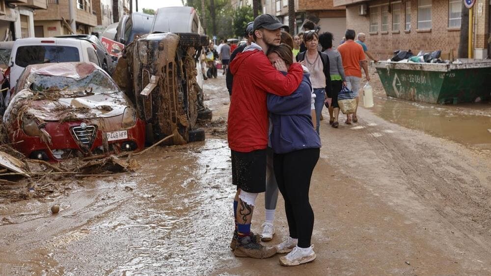 Un vecino abraza a otra vecina en un municipio valenciano afectado por la DANA.