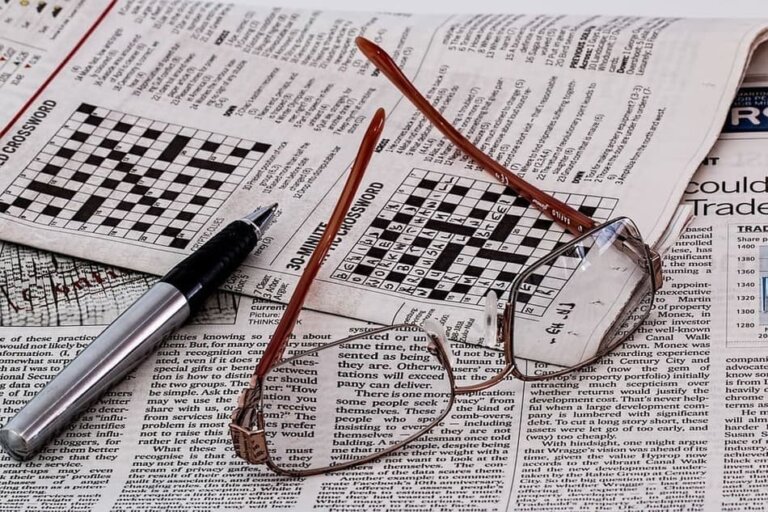 Un periódico abierto en la página de un sudoku y encima están unas gafas de vista.