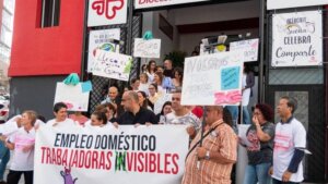 Un grupo de trabajadoras del hogar se manifiestan con pancartas en una calle.