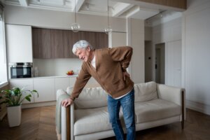 Anciano quejándose amargamente por un dolor en la lumbar.