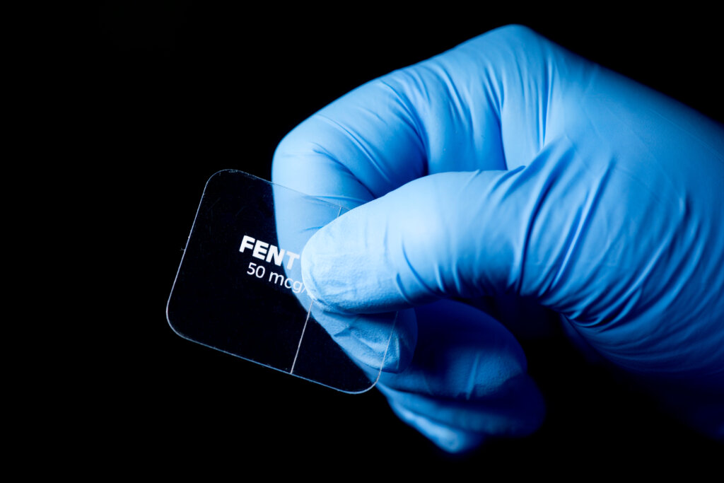 Parche de fentanilo sujetado por la mano de una enfermera con un quirúrgicos.