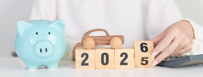 Mujer de fondo montando un collage con 4 fichas de madera donde pasa la última del 5 al 6 para poner un 2026. Encima de este 2026 se ven cuatro montones de monedas cada un más grande que el anterior para acabar concluyendo que el paso del 2025 al 2026 traerá un incremento del SMI.