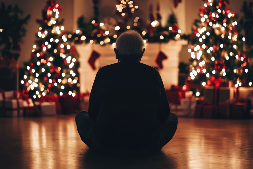 anciano sentado en un salón cálido de noche decorado de navidad 