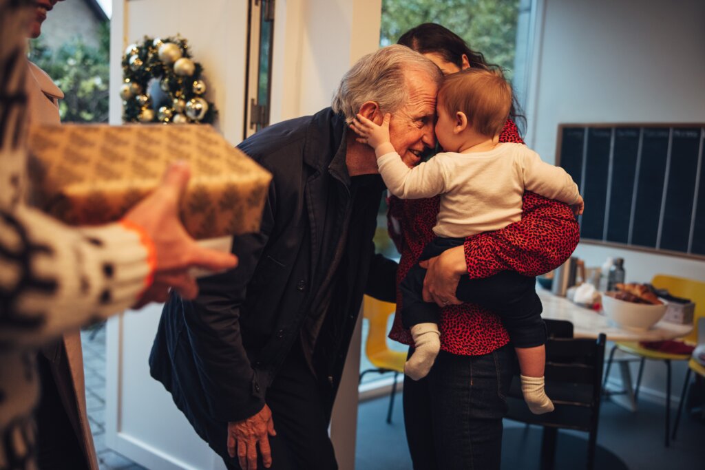 Persona Mayor en navidad Un abuelo en un tierno acercamiento con un bebé en navidad