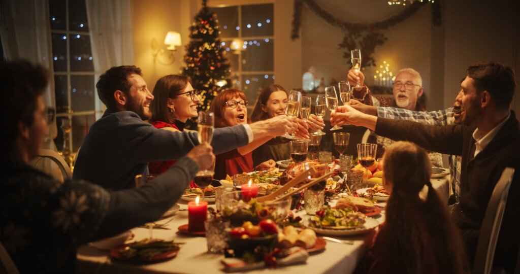Cena familiar de navidad Cena de navidad familiar, todos están con la copa levantada sentados en la mesa para brindar