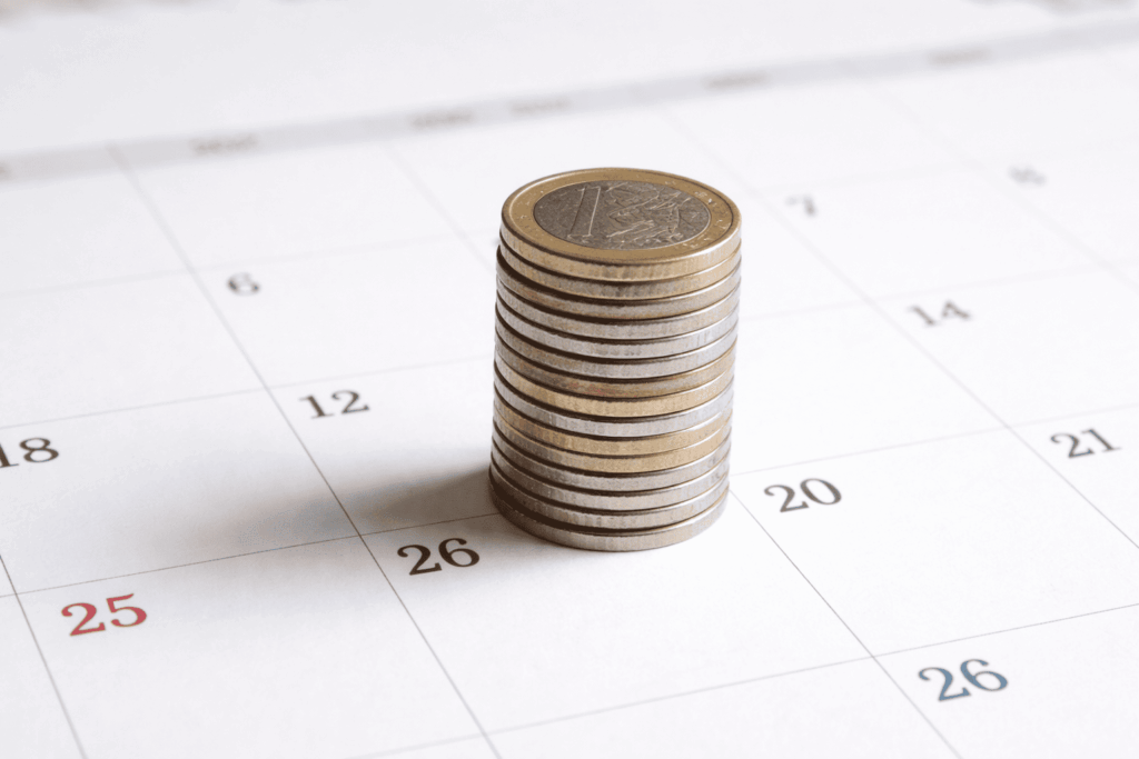 Retrasos prestación ayuda a la Dependencia Columna pequeña de monedas sobre calendario.