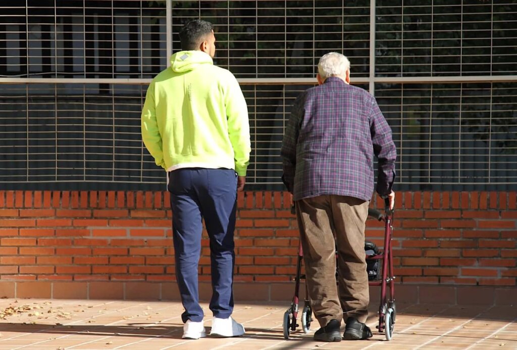 anciano y persona joven caminando anciano y persona joven caminando