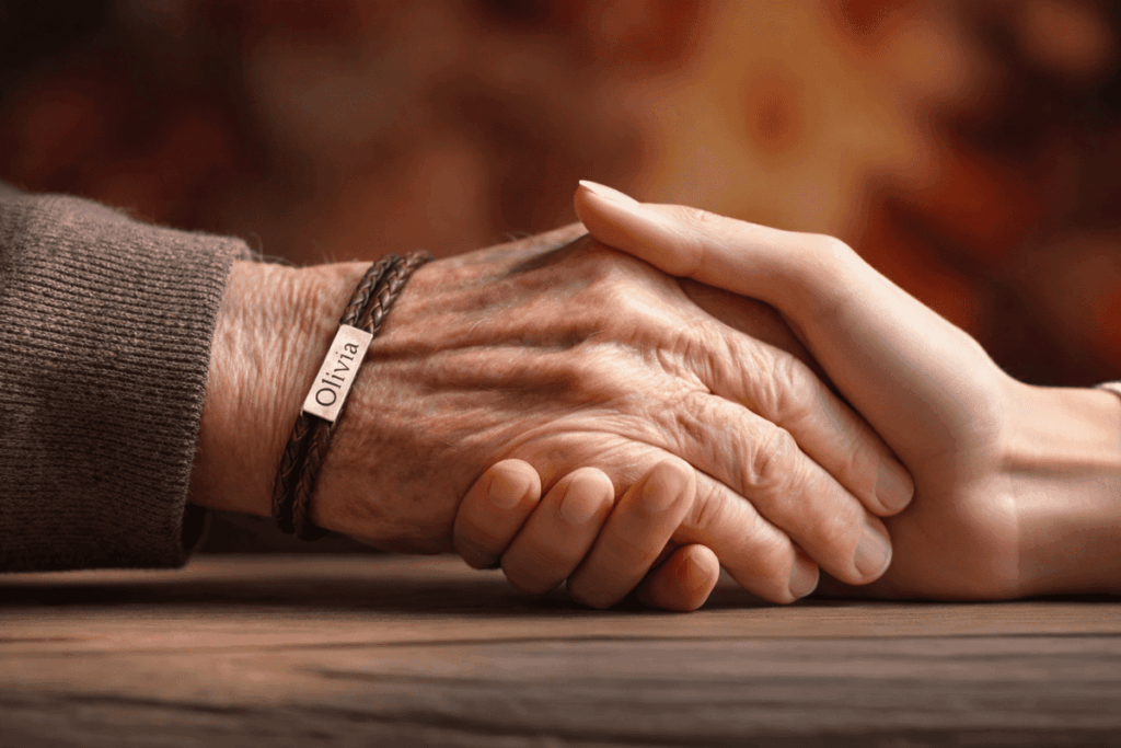 Regalos originales día del Padre Manos de padre e hija entrelazadas, el padre lleva una pulsera con el nombre de su hija personalizada como regalo del día del Padre.