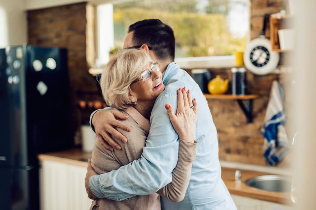 Demencia Senil Familiares dándose un abrazo en una reunión familiar.