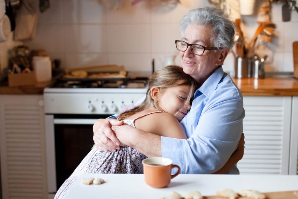 Meriendas de los abuelos Abuela abrazando a su nieta en la cocina